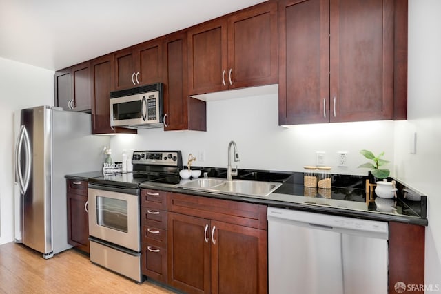 kitchen with light wood-type flooring, sink, and appliances with stainless steel finishes