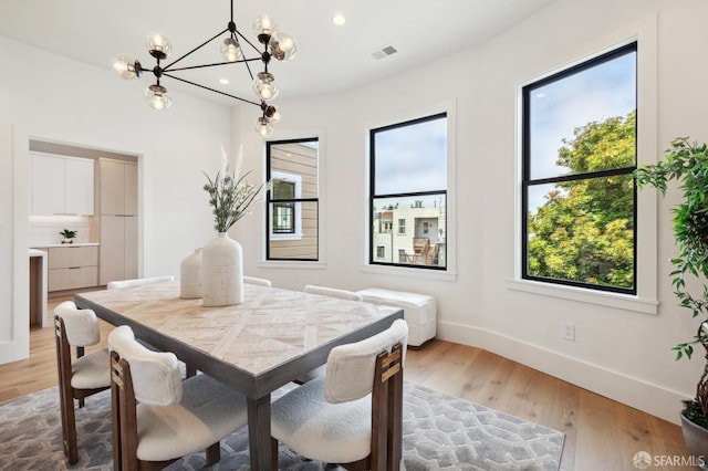 dining room featuring light hardwood / wood-style flooring and a notable chandelier