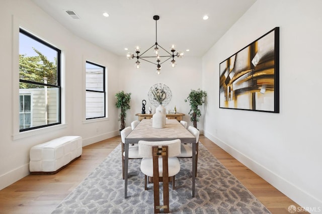 dining space featuring a chandelier and light hardwood / wood-style floors