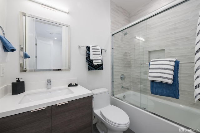 full bathroom featuring vanity, toilet, and combined bath / shower with glass door