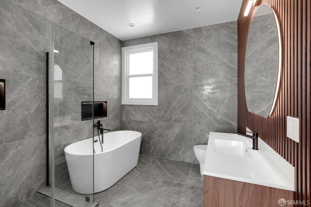 full bathroom featuring vanity, separate shower and tub, toilet, and tile walls