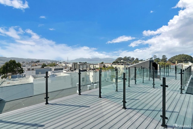 wooden deck featuring a dock and a water and mountain view