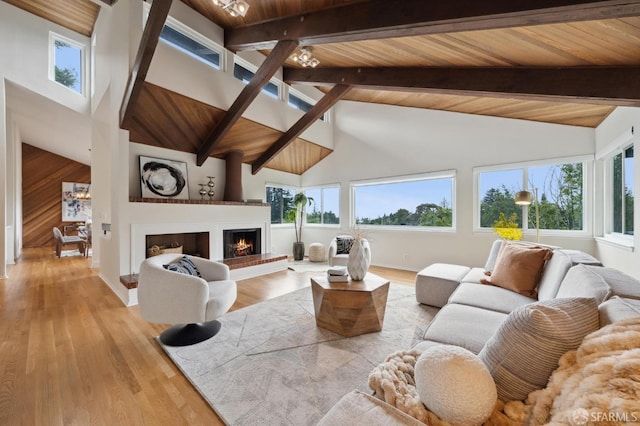 living room featuring high vaulted ceiling, beamed ceiling, wood ceiling, and light wood-type flooring