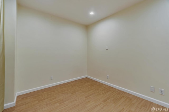 spare room featuring recessed lighting, baseboards, and light wood finished floors