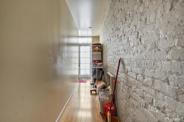 corridor featuring baseboards and wood finished floors