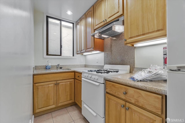 kitchen with a sink, under cabinet range hood, light tile patterned flooring, and white appliances