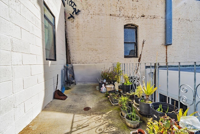 view of side of property featuring fence and brick siding
