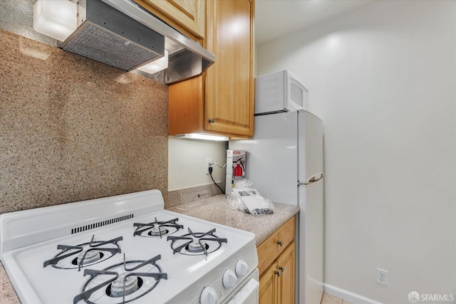 kitchen featuring white appliances and under cabinet range hood