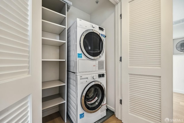 washroom featuring light hardwood / wood-style floors and stacked washer and dryer