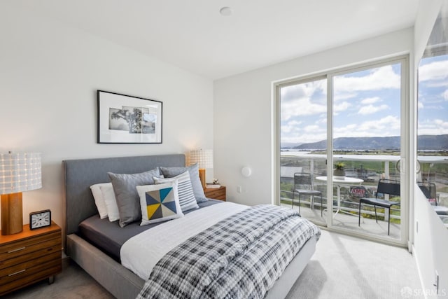 bedroom featuring light colored carpet, access to outside, and a mountain view