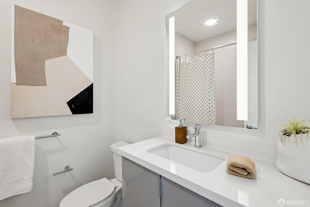 full bathroom featuring toilet, vanity, and curtained shower