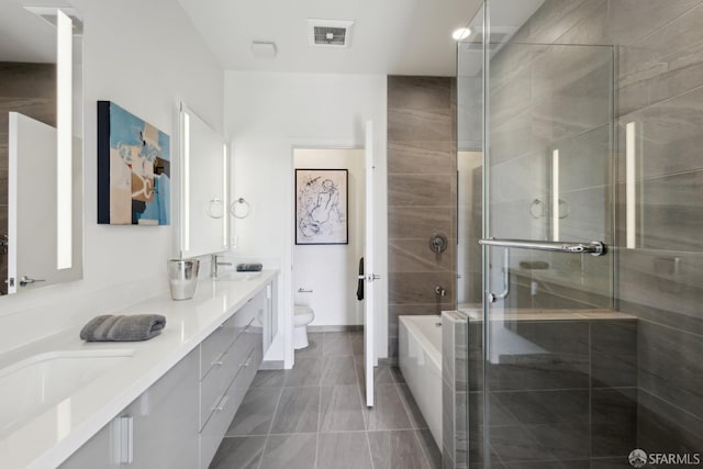 full bathroom with a shower stall, toilet, double vanity, a garden tub, and tile patterned flooring