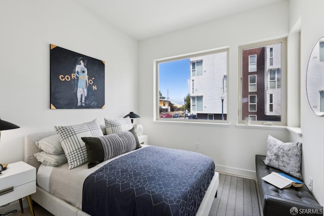 bedroom featuring hardwood / wood-style flooring and baseboards