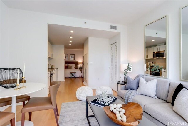 living area featuring recessed lighting, visible vents, and light wood-style flooring