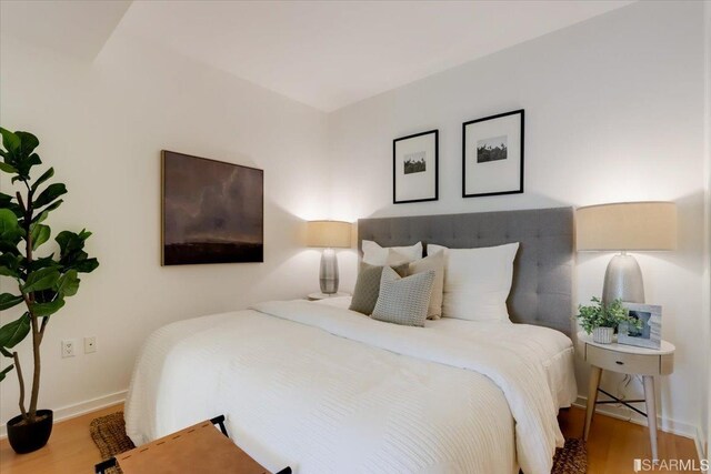 bedroom with baseboards and wood finished floors