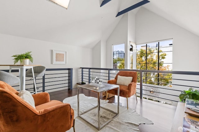 living area with hardwood / wood-style floors, high vaulted ceiling, and a wealth of natural light