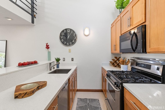 kitchen featuring light stone counters, light tile patterned floors, sink, and appliances with stainless steel finishes