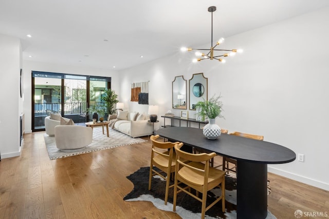 dining area with an inviting chandelier and light hardwood / wood-style flooring