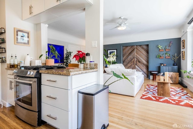 1490 Francisco St Unit 3, San Francisco, CA 94123 - kitchen featuring stainless steel gas range, wood finished floors, white cabinets, and ceiling fan