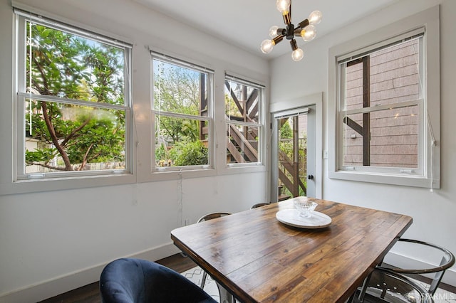 dining area with a notable chandelier and dark hardwood / wood-style flooring