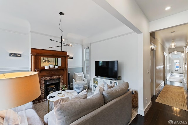 living room featuring a fireplace, a chandelier, and wood-type flooring