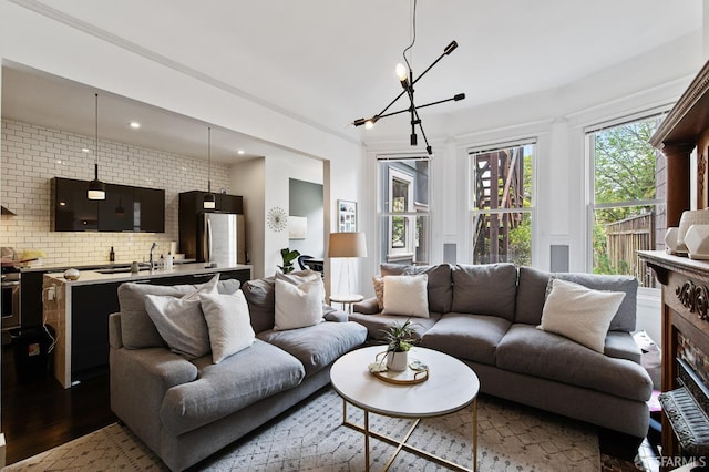 living room featuring light hardwood / wood-style floors, a notable chandelier, and brick wall