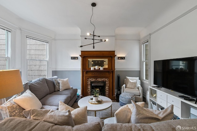 living room with a brick fireplace and an inviting chandelier