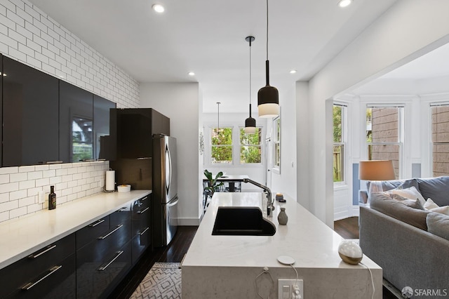 kitchen with a spacious island, stainless steel fridge, sink, and pendant lighting