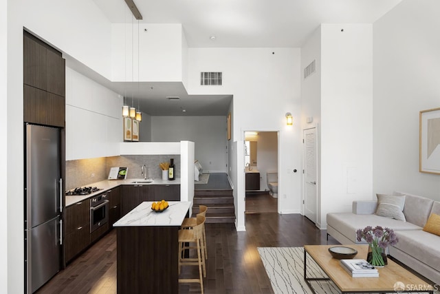 1788 Clay St Unit 103, San Francisco, CA 94109 - kitchen featuring appliances with stainless steel finishes, a sink, a towering ceiling, modern cabinets, and dark brown cabinetry