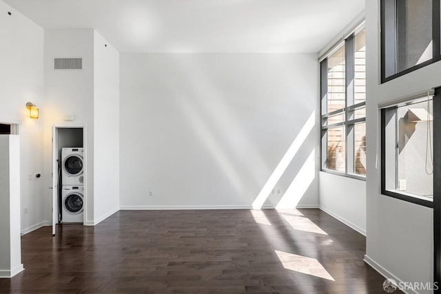 1788 Clay St Unit 103, San Francisco, CA 94109 - unfurnished living room featuring stacked washer / drying machine, dark wood finished floors, a high ceiling, and baseboards