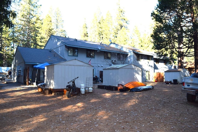 back of house featuring a storage unit