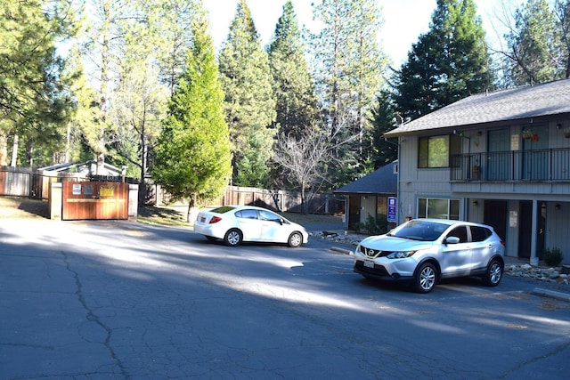 view of vehicle parking with fence