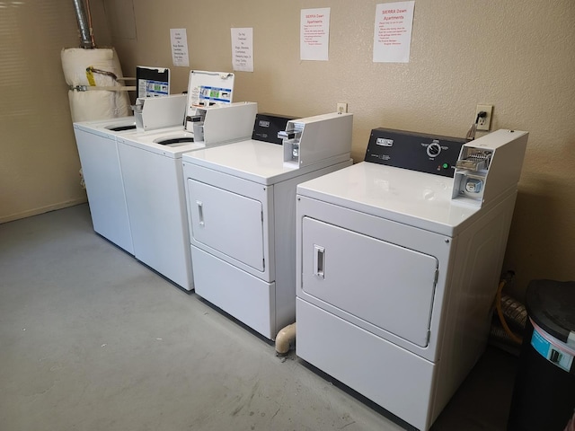 shared laundry area featuring a textured wall and washer and clothes dryer