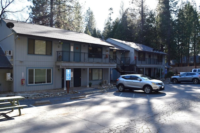 view of front of house featuring stairs and a shingled roof