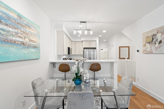 dining space featuring recessed lighting, light wood-type flooring, and baseboards