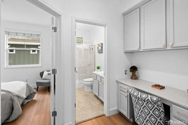 interior space featuring toilet, a stall shower, ensuite bathroom, wood finished floors, and vanity