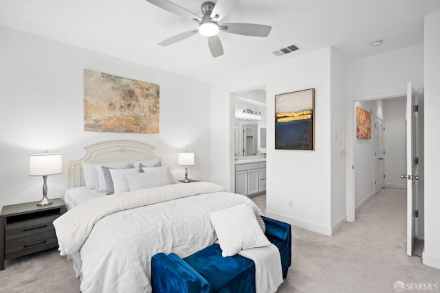 bedroom featuring visible vents, ceiling fan, baseboards, light carpet, and ensuite bathroom