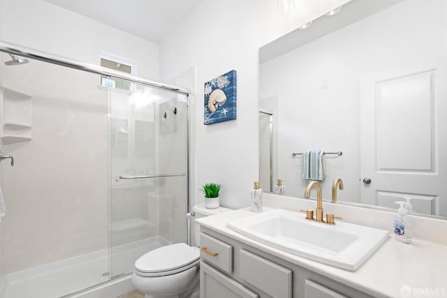 bathroom featuring vanity, a shower stall, and toilet