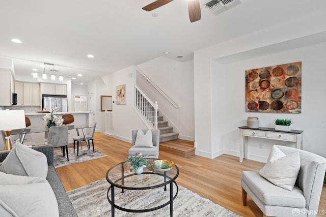 living room with recessed lighting, visible vents, stairs, and light wood finished floors