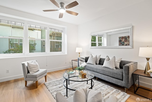 living room featuring a ceiling fan, light wood-style floors, and baseboards