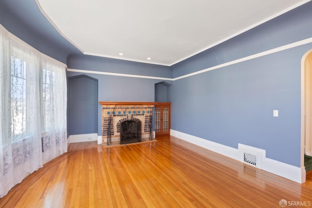 47 Brunswick St, San Francisco, CA 94112 - unfurnished living room featuring visible vents, wood finished floors, a fireplace, baseboards, and arched walkways