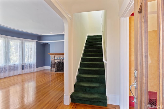 47 Brunswick St, San Francisco, CA 94112 - staircase featuring a brick fireplace, arched walkways, baseboards, and wood finished floors