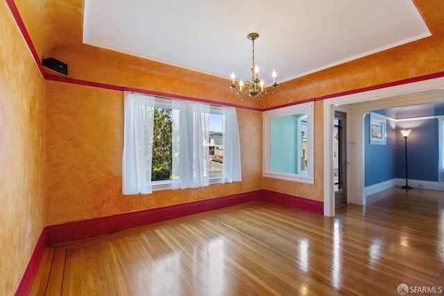 47 Brunswick St, San Francisco, CA 94112 - empty room featuring baseboards, arched walkways, wood finished floors, and a chandelier