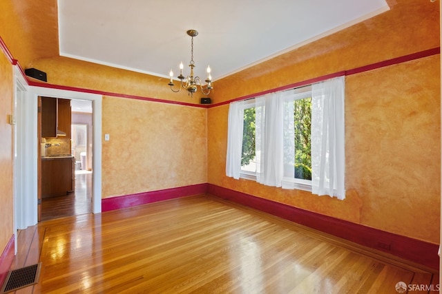 47 Brunswick St, San Francisco, CA 94112 - empty room with visible vents, wood finished floors, baseboards, an inviting chandelier, and ornamental molding