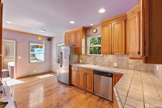 47 Brunswick St, San Francisco, CA 94112 - kitchen featuring backsplash, a sink, light wood-style floors, tile counters, and stainless steel appliances