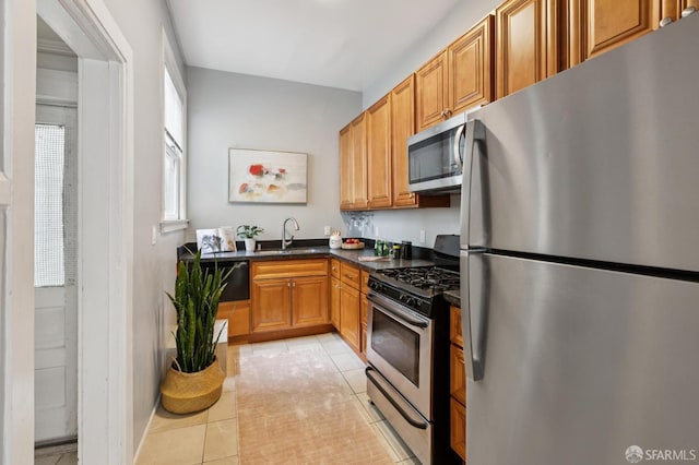 1250 Vallejo St Unit 1, San Francisco, CA 94109 - kitchen featuring appliances with stainless steel finishes, dark countertops, light tile patterned floors, and brown cabinets