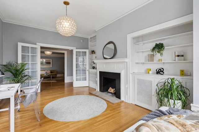1250 Vallejo St Unit 1, San Francisco, CA 94109 - living room with crown molding, wood finished floors, built in shelves, and a fireplace with raised hearth