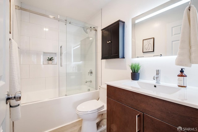 full bathroom featuring toilet, shower / bath combination with glass door, vanity, and hardwood / wood-style floors