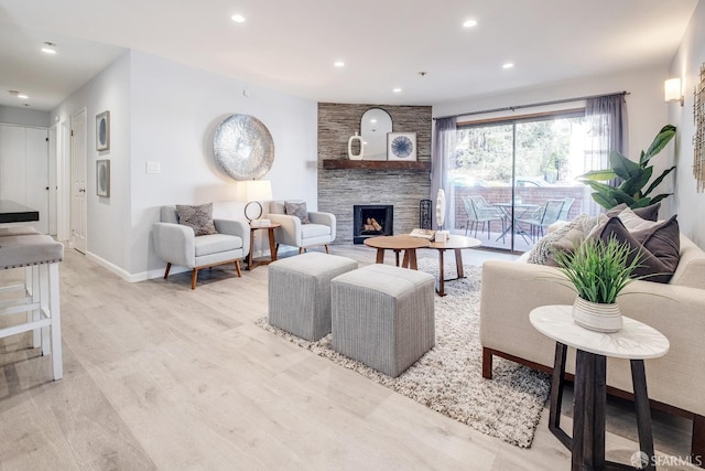 living room with a fireplace and light wood-type flooring