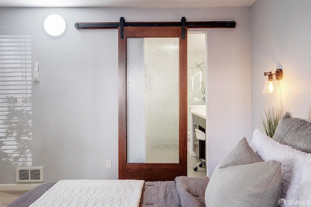 bedroom with ensuite bathroom and a barn door